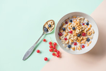Bowl Of Oat Cereal With Blueberry,red Currant And Spoon.Oat Ring Cereal With Berries And Milk.concept Of Healthy Breakfast, Healthy Eating. Flat Lay, Minimalism, Top View. Place For Text.