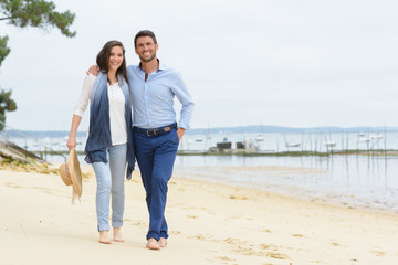 beautiful young couple walking on the shore