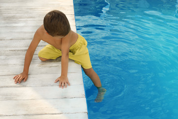 Poster - Little child near outdoor swimming pool. Dangerous situation