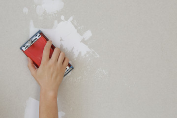 process of sanding wall with a sanding block after skim coating. preparation before painting. renova