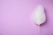 Sweet cotton candy on violet background, top view. Space for text