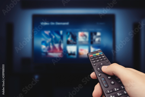 Fotomural VOD service screen with remote control in hand