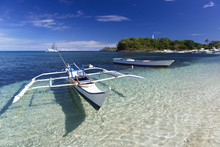 Tropical Landscape With  Filipino Traditional Banka Fishing Outrigger Boat On A White Sand Beach, Beautiful Clear Turquoise Water. Malapascua Island, Philippines.