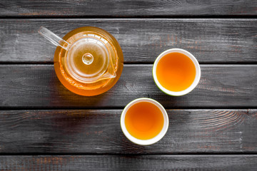 Wall Mural - Tea in pot and cups on wooden background top view