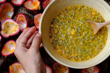 Woman Hand Take Soft Pulp And Seeds Inside Passion Fruit Cut In Half