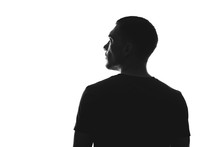 Silhouette Of Man From Behind On A White Background Looks Away