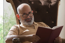 Senior Man Reading A Book At Home	