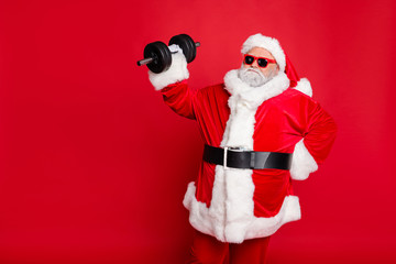 Portrait of his he nice attractive fat overweighed bearded Santa working out barbell physical exercise workout calories diet regime isolated over bright vivid shine red background