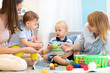 © Oksana Kuzmina - Kids playing on floor with educational toys. Toys for preschool and kindergarten. Children in nursery or daycare. Babies with teachers in creche