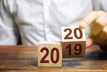 Two Wooden Blocks With Numbers 2019 And 2020. The Concept Of The Beginning Of The New Year. New Objectives. Next Decade. Trends And Changes In The World. Build Plans And Goals. Time Report