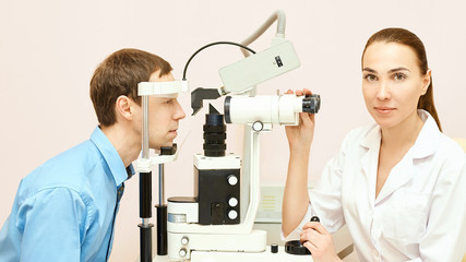 Wall Mural - Eye ophthalmologist exam. Eyesight recovery. Astigmatism check concept. Ophthalmology diagmostic device. Beauty girl portrait in clinic. Man patient