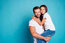Portrait Of Lovely Man With Brunet Hair Cut Holding His Daughter Having Long Hair Wearing White Casual T-shirt Denim Jeans Isolated Over Blue Background