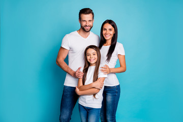 Wall Mural - Portrait of lovely family looking with toothy smile wearing white t-shirt denim jeans isolated over blue background