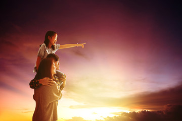 Wall Mural - asian family standing and watching the sunset