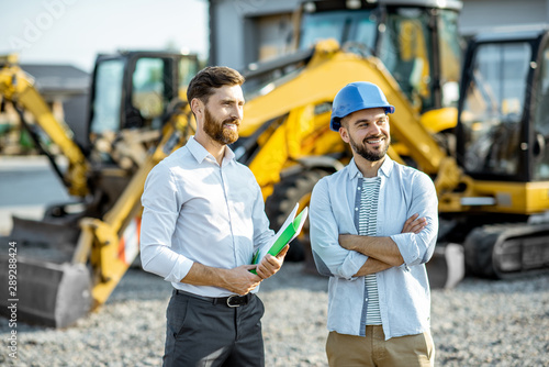 Cuadros en Lienzo Builder choosing heavy machinery for construction with a sales consultant standi