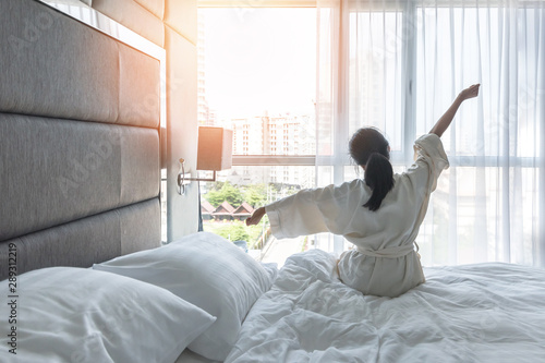 Fotografía Work-life quality balance concept with lazy lifestyle of Asian girl on bed relax