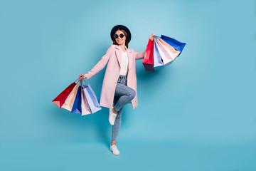 Poster - Full body photo of enthusiastic candid lady in eyewear eyeglasses go shopping buy purchases wear pink coat denim jeans isolated over blue background