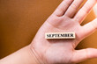 © jaturonoofer - Hand hold wooden block of September