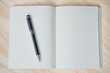 © Raul - white paper notebook in blank with pen on wood background