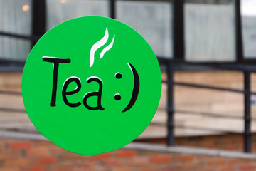 green retro outdoor tea sign. pointer in the morning on the street