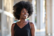 © Llstock - Portrait of smiling young black woman with sunlight flare and copy space