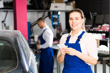 Woman mechanic writing job sheet