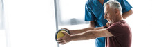 Panoramic Shot Of Middle Aged Man Exercising With Ball Near Doctor