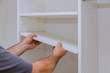 © ungvar - Worker sets the shelf for closet cabinet