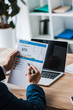 © LIGHTFIELD STUDIOS - cropped view of man holding pen near paper with credit report letters near laptop with blank screen on desk