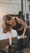 © bongkarn - Beautiful asian athletic woman lifting weights inside home gym