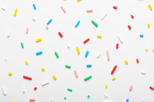Flat Lay Of Colorful Sprinkles Over White Background, Festive Decoration
