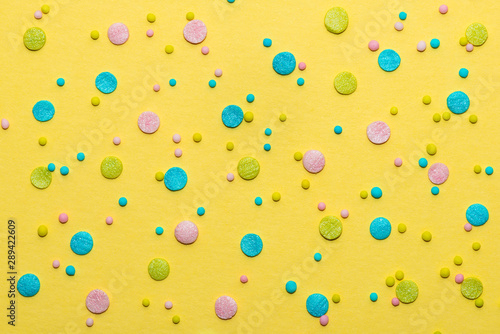 colorful round sprinkles over yellow background, decoration for cake and baker
