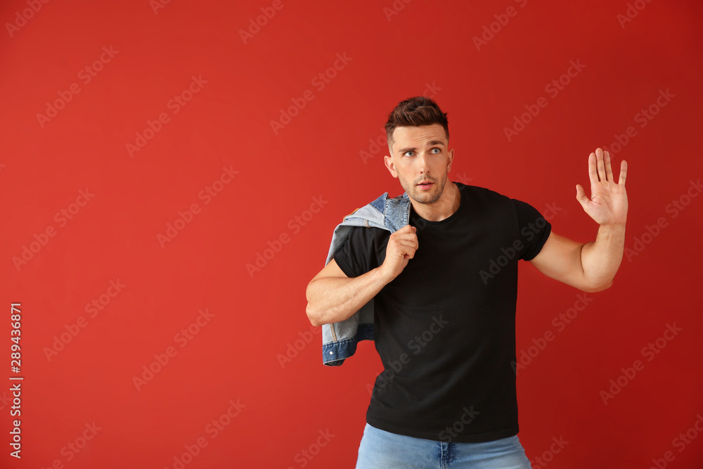 Handsome young man dancing against color background