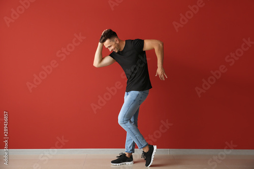 Fotografía Handsome young man dancing against color wall