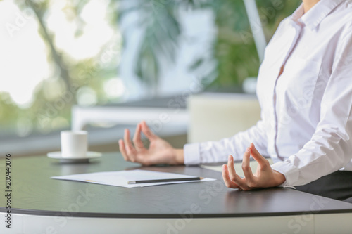 Fotomural Young businesswoman meditating at workplace in office