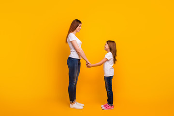 Poster - Full length profile side photo of lovely mommy with her kid having long haircut holding hands isolated over yellow background