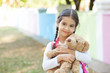 © kaganskaya115 - Adorable little child girl with a teddy bear outdoors. School time.