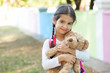 © kaganskaya115 - Adorable little child girl with a teddy bear outdoors. School time.
