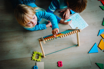 Wall Mural - little boy and girl learn to write and calculate numbers