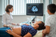 © Nejron Photo - Pregnant woman and her son on utltrasonographic examination at hospital