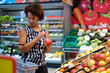 © Nejron Photo - Pretty black woman choosing fruits in a grocery store