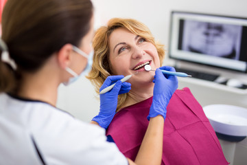 dentist with happy female patient at clinic