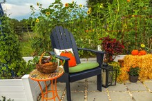 Outdoor Patio And Raised Garden Beds At Sunset, Decorated For Autumn With Pumpkins, Plants, Hay Bales, Chrysanthemum And Lanterns