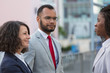 © Mangostar - Business partners discussing contract outside. Multiethnic business man and women standing in city street and talking. Meeting outside concept
