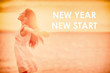 © Maridav - New Year Resolution woman feeling happy emotion free in sunset freedom with text NEW YEAR NEW START on copy space nature beach background.