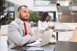 © Mangostar - Pensive business leader thinking over new plan over cup of coffee. Young black woman drinking coffee and using tablet in background. Digital communication concept