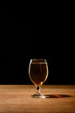 Fototapeta Lawenda - glass of fresh beer on wooden table isolated on black