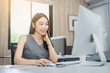 © NewSaetiew - Portrait of beautiful happy smiling young businesswoman working on her computer in the office.,sitting on workplace.,Happy working.