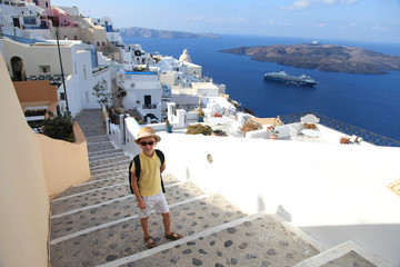 Portrait of young boy in hat on the streets of Fira, Santorini, Greece