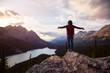© edb3_16 - Adventurous girl with open arms standing on the edge of a cliff overlooking the beautiful Canadian Rockies and Peyto Lake during a vibrant summer sunset. Taken in Banff National Park, Alberta, Canada.